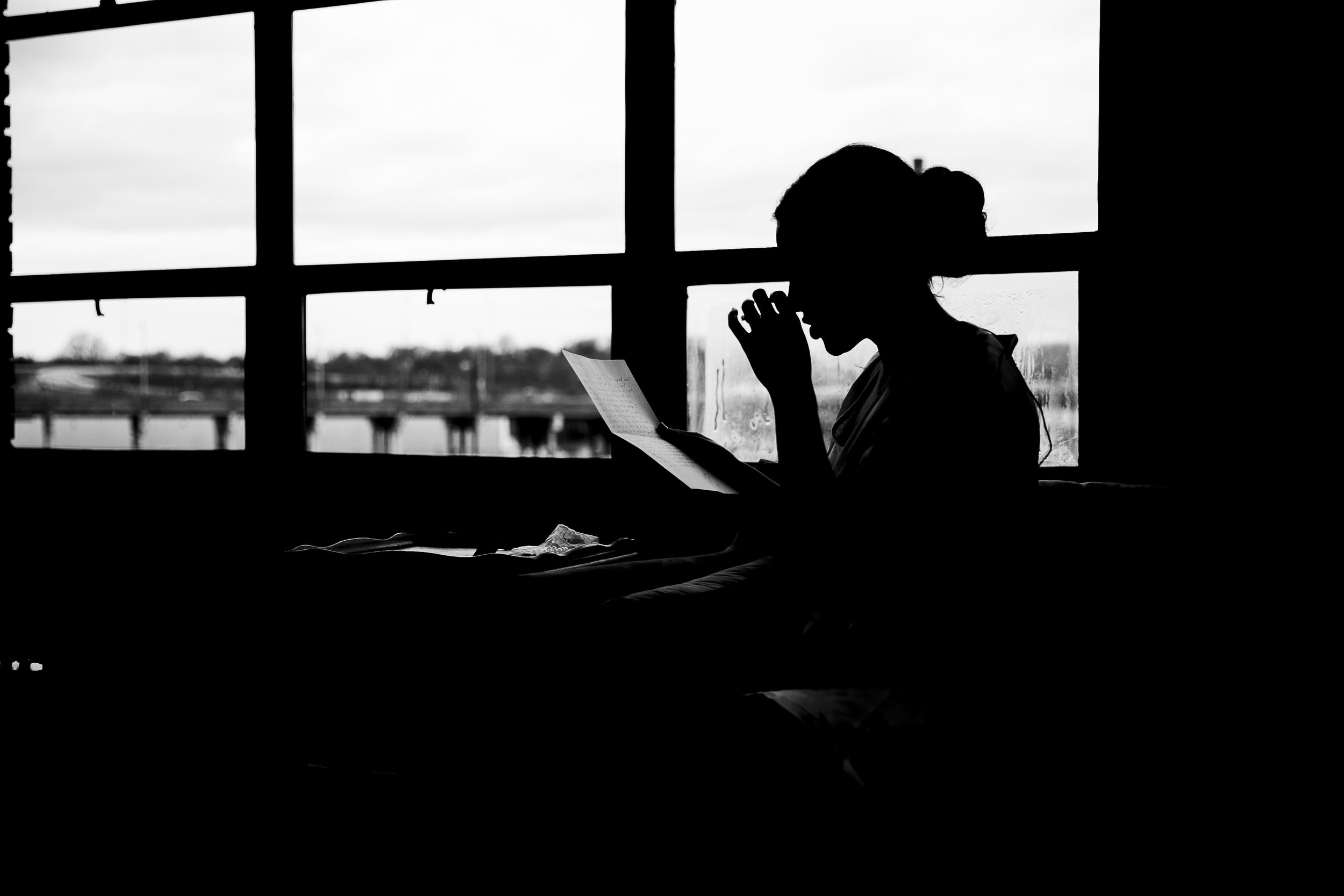 silhouette of bride reading letter