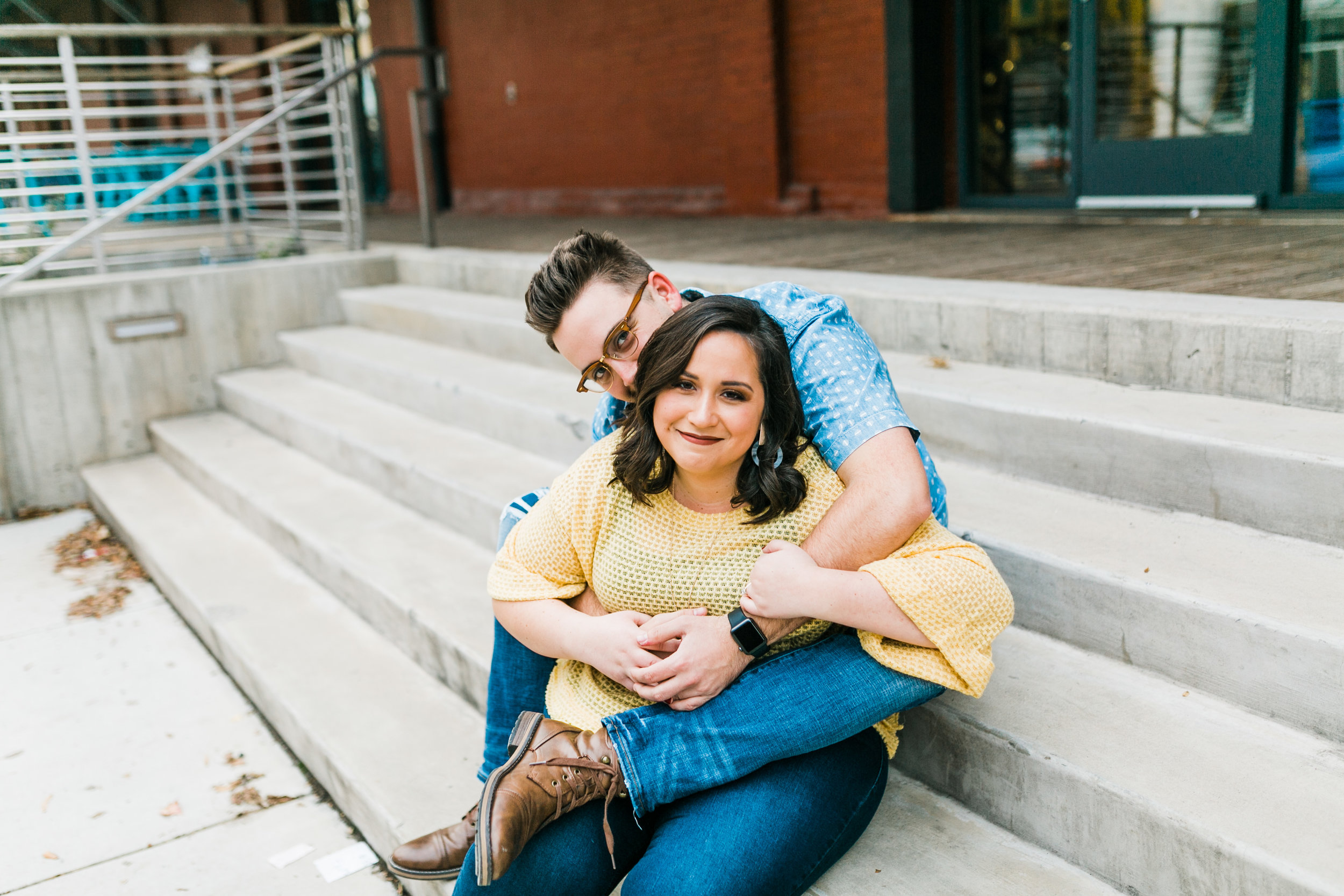 couple snuggling on steps outside of taproom engagement photos downtown knoxville